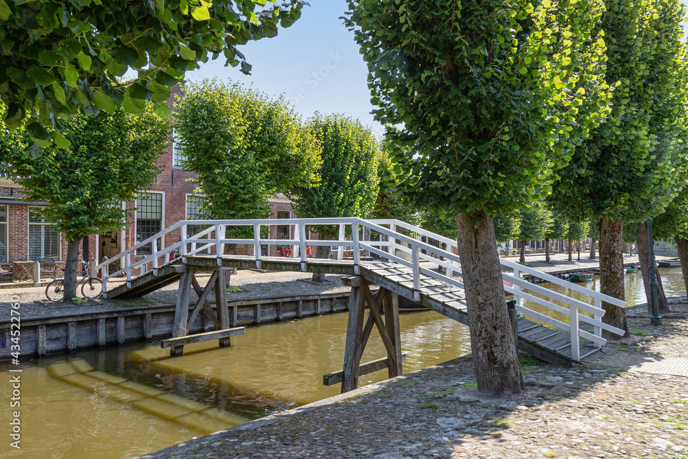 A wooden white bridge over the canal in the picturesque town of Sloten in the Netherlands