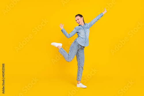 Full body photo of positive joyful young woman look empty space enjoy weekend isolated on yellow color background