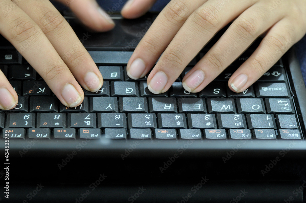 Girl typing on her laptop computer. Close up of fingers on the keyboard. Girl typing on her laptop computer. Close up of fingers on the keyboard.