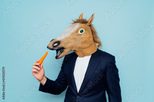 Obraz na plátne Man with horse mask eating.