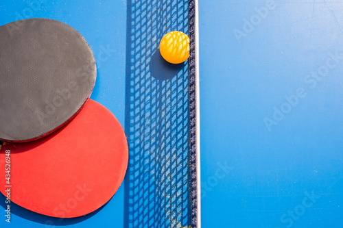 Blue table tennis or ping pong. Outdoor tablet tennis. Close-up ping-pong. Accessories for table tennis racket and ball on a blue tennis table. Sport.