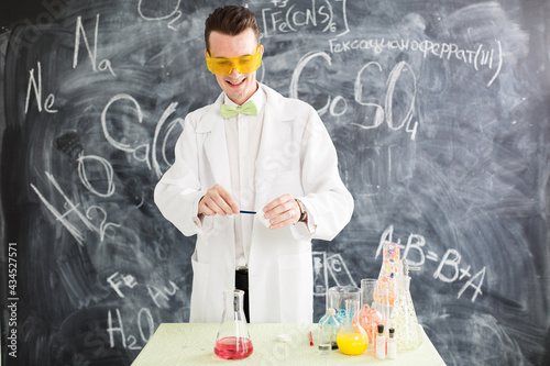 Chemist carries chemistry experiment in laboratory. Test-tubes with chemical reagent. Chemical Laboratory. Chemistry lesson. Study chemistry. Scientist at laboratory. Crazy professor. Yellow glasses