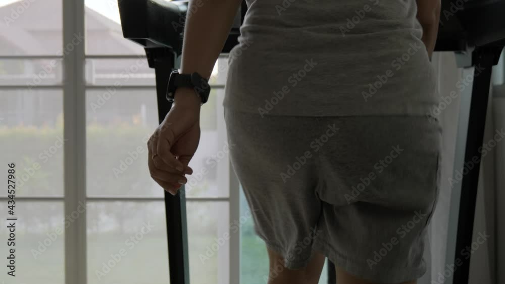 Woman with bouncing big hip or buttom doing the exercise on the treadmill at home.