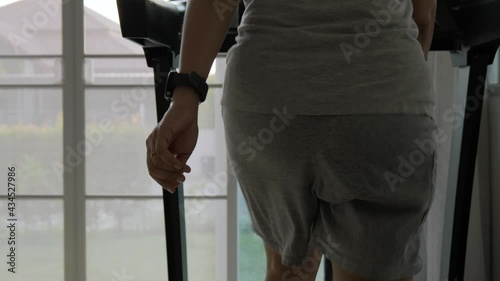 Woman with bouncing big hip or buttom doing the exercise on the treadmill at home. photo