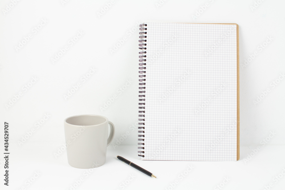 pen with notepad and cup on white background in office pen with notepad and cup on white background in office