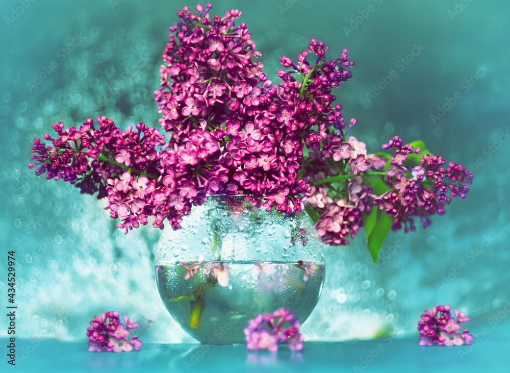 A bouquet of lilacs in a transparent vase. Artistic photo with sparkling bokeh and very soft selective focus. Shallow depth of field for an artistic idea. Spring bouquet.