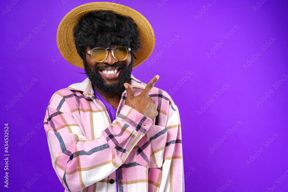 Cheerful african american man pointing finger at copy space Cheerful african american man pointing finger at copy space