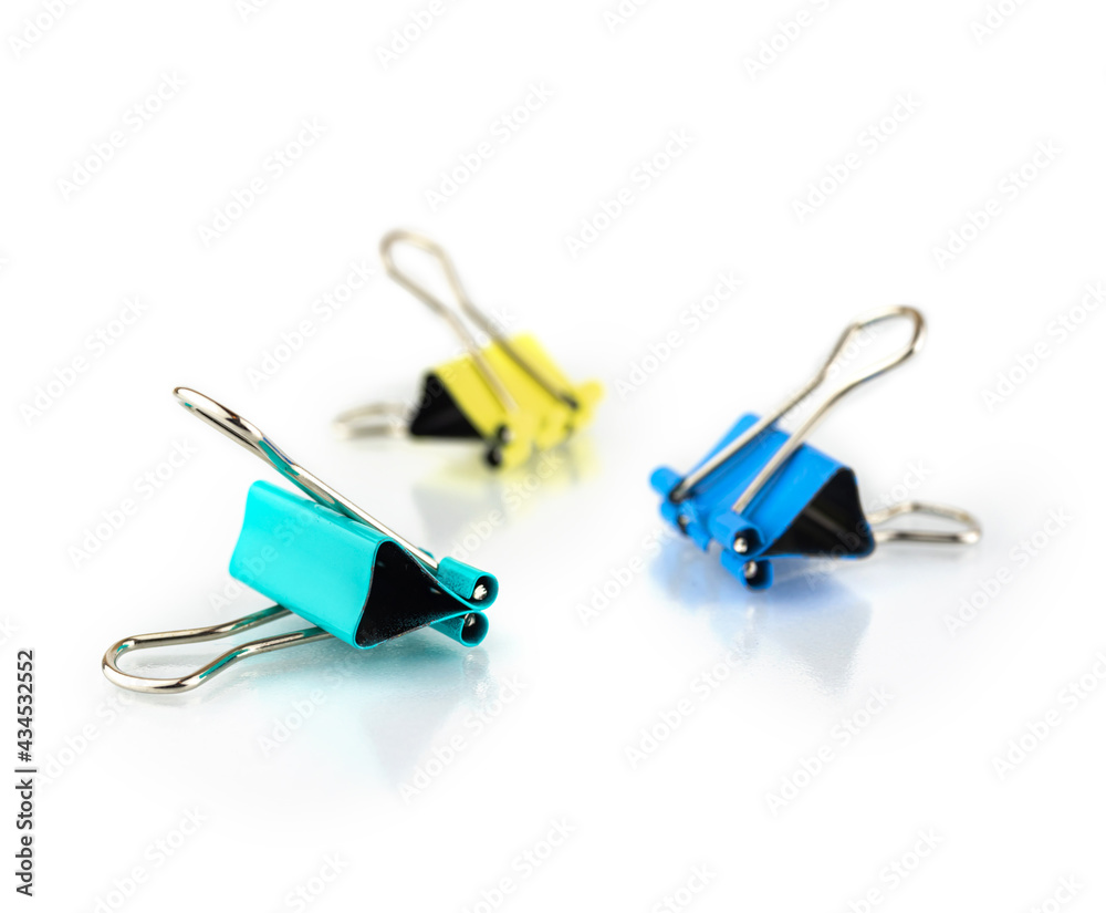 Three colorful paper clips binder isolated on white background with reflection, stationery photo Three colorful paper clips binder isolated on white background with reflection, stationery photo