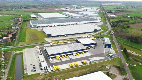 Aerial Shot of Industrial Warehouse/ Storage Building/ Loading Area where Many Trucks Are Loading/ Unloading Merchandise. Shot on Phantom 4K UHD Camera. photo