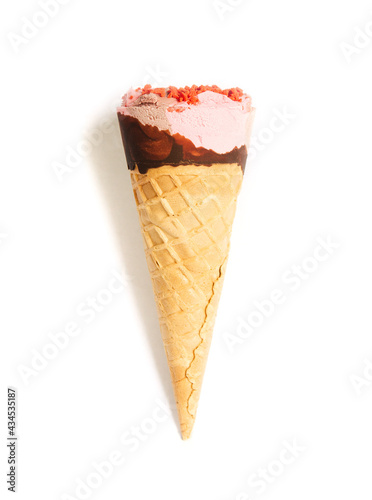 
Ice cream cone close up. Pink ice cream scoop in a waffle cone on an isolated white background. Strawberry or raspberry flavor sweet dessert decorated with chocolate and colorful sprinkles, close up