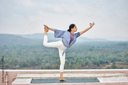 Young athletic woman practicing yoga outdoors