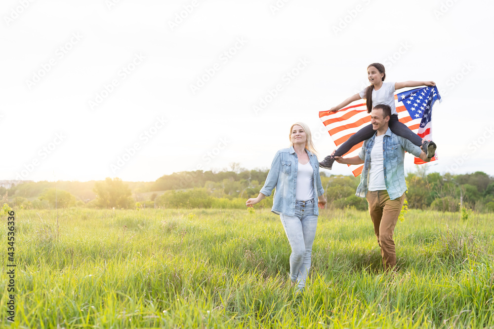 Patriotic holiday. Happy family, parents and daughters children girl with American flag outdoors. USA celebrate 4th of July. Patriotic holiday. Happy family, parents and daughters children girl with American flag outdoors. USA celebrate 4th of July.