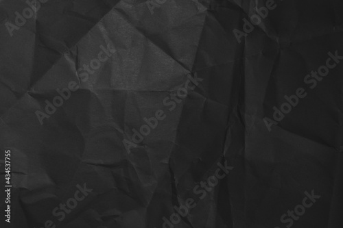 Black background of crumpled paper in the dark