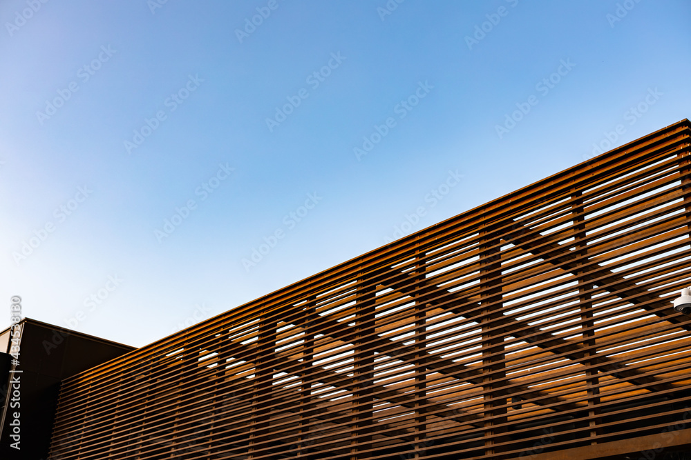 Obraz premium Wooden slat shading structure with roof against sky