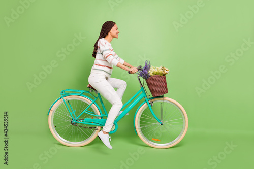 Fototapeta Naklejka Na Ścianę i Meble -  Full body profile side photo of young afro girl happy positive smile ride cycle travel isolated over green color background
