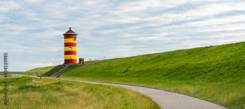 Beautiful red and yellow lighthouse in Friesland, Germany photo