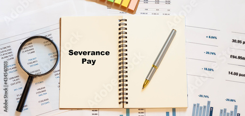 Severance Pay on white blank notepad with financial papers