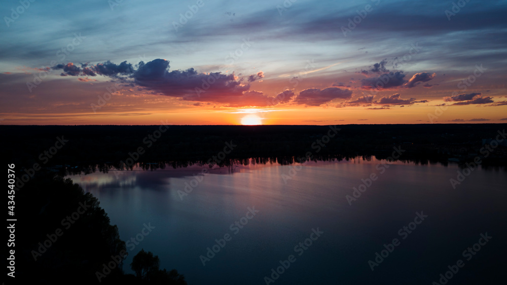 Beautiful sunset with clouds over the river under construction houses in the dark, Ukraine, Kiev on May 6. Beautiful sunset with clouds over the river under construction houses in the dark, Ukraine, Kiev on May 6.