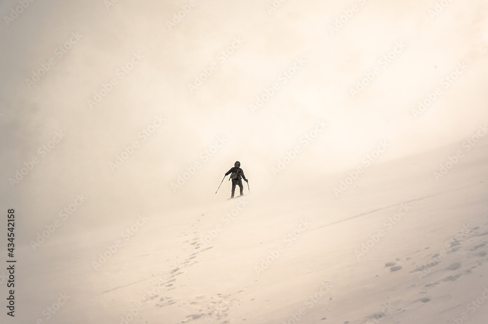 Monkh Saridag mountain, Mondy, Buryatia, Russia - 04 25 2021: a man walking in snowy mountains Monkh Saridag mountain, Mondy, Buryatia, Russia - 04 25 2021: a man walking in snowy mountains