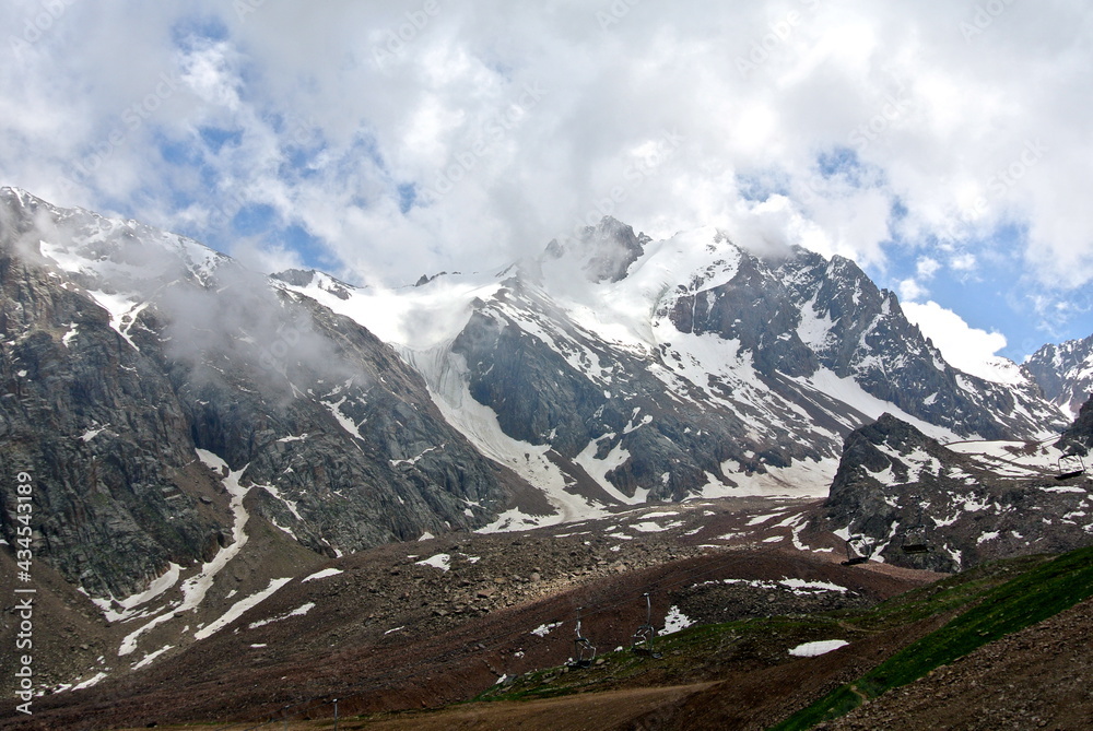 high mountains landscape, snow melting on the peaks, beautiful cloudscape