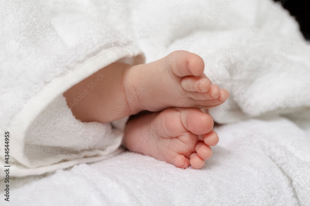 Infants Ideas and Concepts. Macro Close-up Image of a Four Week Old Baby Boy Crossed Feet Over White Towel. Infants Ideas and Concepts. Macro Close-up Image of a Four Week Old Baby Boy Crossed Feet Over White Towel.