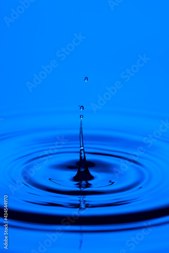 Abstract Macro Shot of Round Water Splash With Long Thin Stem Falling With Water Ripples.