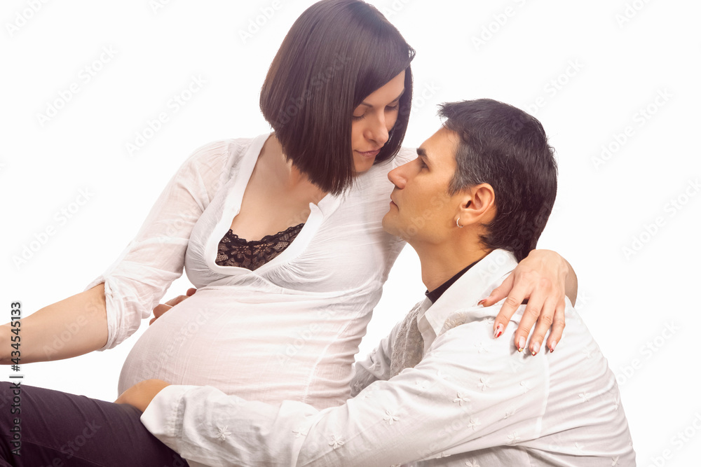 Portrait of Caucasian Man Together with Pregnant Wife Sitting Together Embraced Over White Background Portrait of Caucasian Man Together with Pregnant Wife Sitting Together Embraced Over White Background
