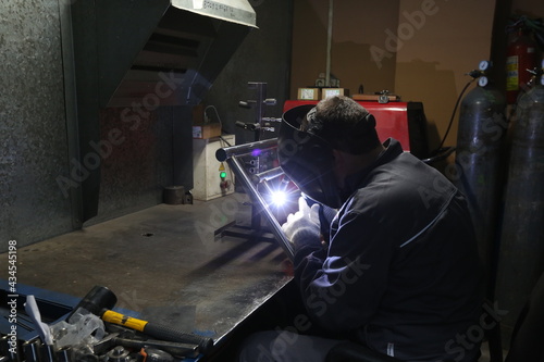 Welder at work in the production shop, welds the seam on the towel rails