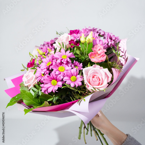 Colorful flower bouqet arrangement. Summer flowers held by florist in hand close up. Flowers for wedding and happy occasions. © roman