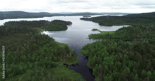 Blue lake, islands and green forests from above on a cloudy summer day. Lake landscape in Lapland.	 photo