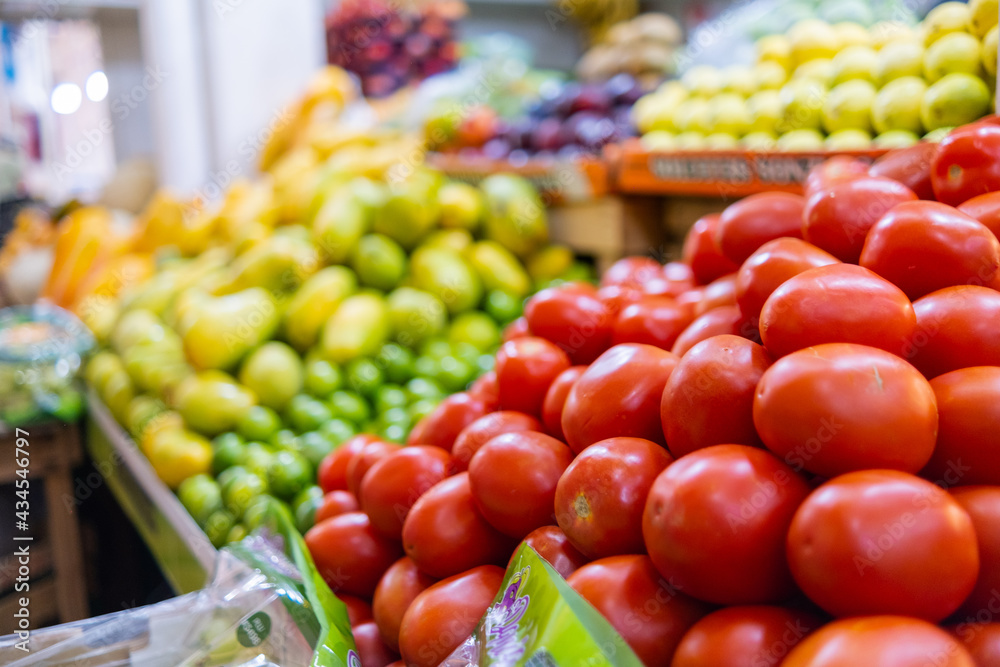 Colorful vegetable and fruit stand with tomatoes, grapes, mangoes, and more