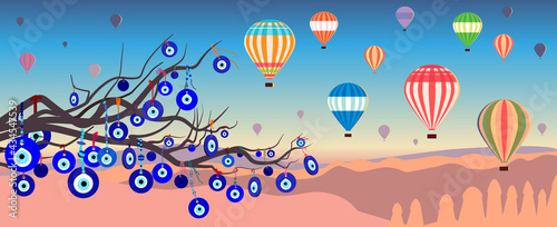 Hot air balloons over the mountains in Love Valley and an evil eye tree with Turkish evil eye amulets (nazar) against the sunset sky; vector illustration in a flat style.