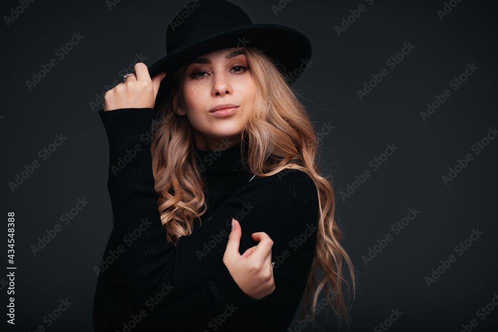 Portrait of a young beautiful woman in black hat on black background Portrait of a young beautiful woman in black hat on black background