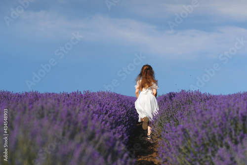 Fototapeta Naklejka Na Ścianę i Meble -  running girl in white dress in lavender