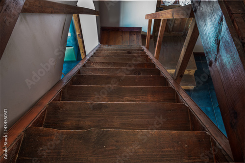 Photo of descending old wooden staircase