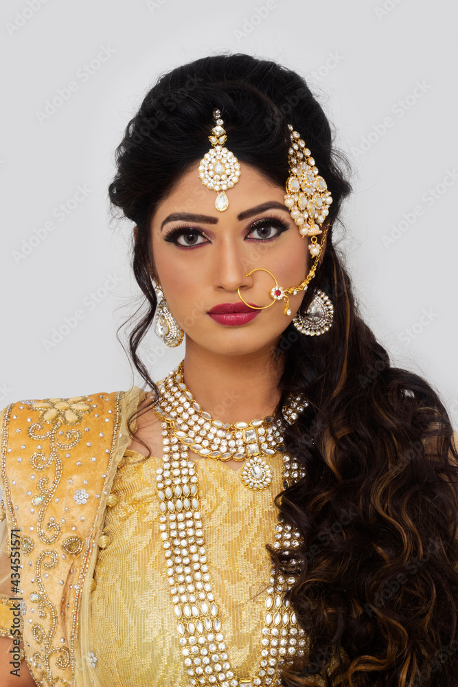 Woman in bridal yellow sari and silver jewelry. Looking at camera Woman in bridal yellow sari and silver jewelry. Looking at camera