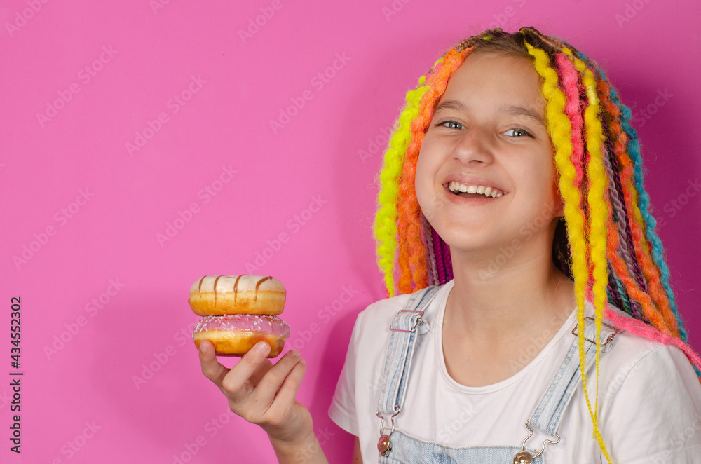 girl with colored dreads and sweet donut on pink background girl with colored dreads and sweet donut on pink background