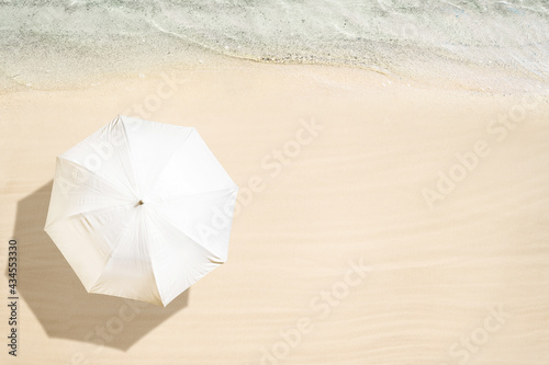 Fototapeta Naklejka Na Ścianę i Meble -  White umbrella on tropical sand beach. Top and aerial view. Ocean coastline. Drone photo. Background
