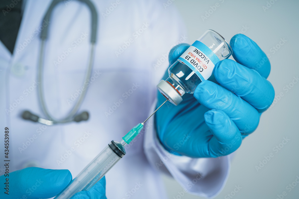 Male Doctor wearing PPE with a stethoscope on shoulder and holding syringe COVID-19 vaccine CORONA vaccine concept Healthcare and Medical Male Doctor wearing PPE with a stethoscope on shoulder and holding syringe COVID-19 vaccine CORONA vaccine concept Healthcare and Medical