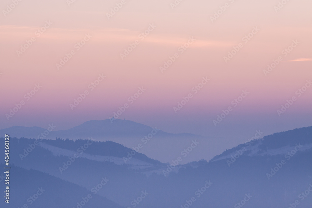 Mountain panorama at sunrise with clouds fog and pink sky Mountain panorama at sunrise with clouds fog and pink sky