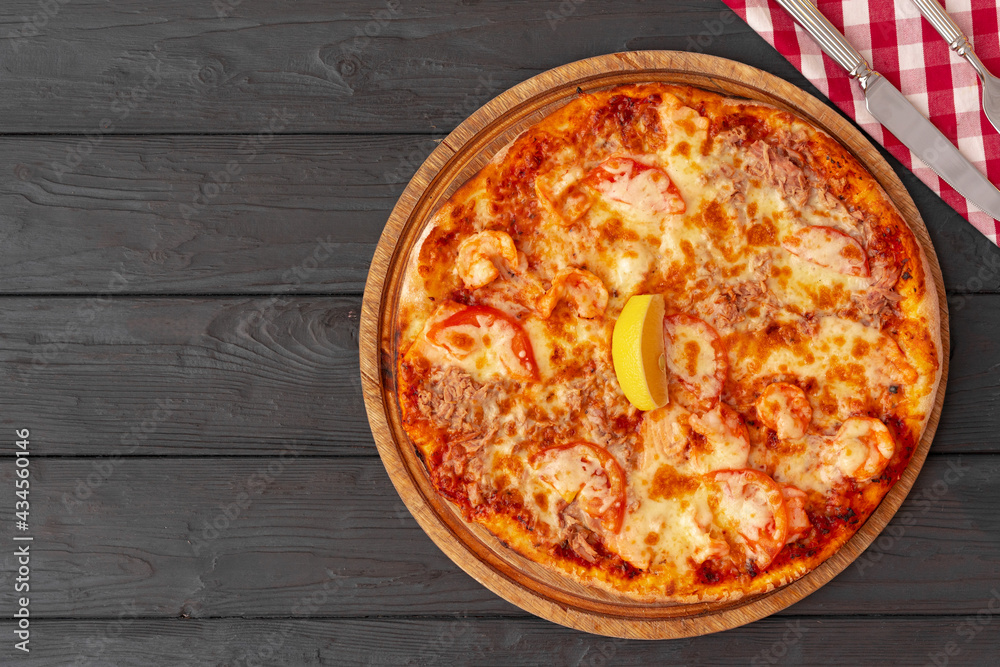 Tasty pizza on black wooden background top view Tasty pizza on black wooden background top view
