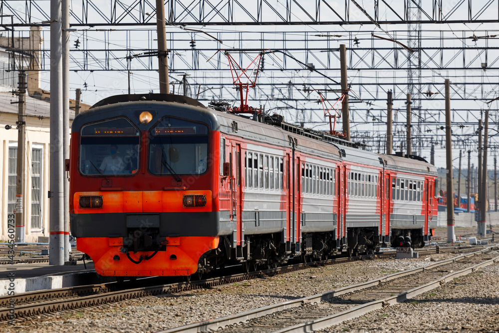 The electric train is red at the station in the daytime. The electric train is red at the station in the daytime.