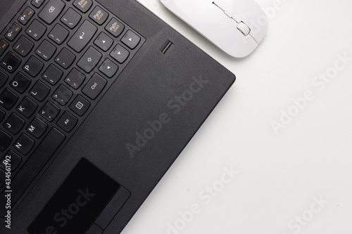 Flat lay, top view black laptop and white mouse on white office desk with copy space, workspace blank. Minimal desk concept. 2