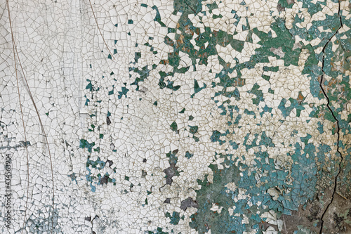 Cracked paint on cracked concrete wall © Aleksejs