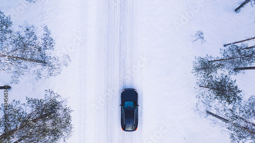 Canvas-taulu Aerial top view from drone of suv vehicle driving on snowy ice road exploring lo
