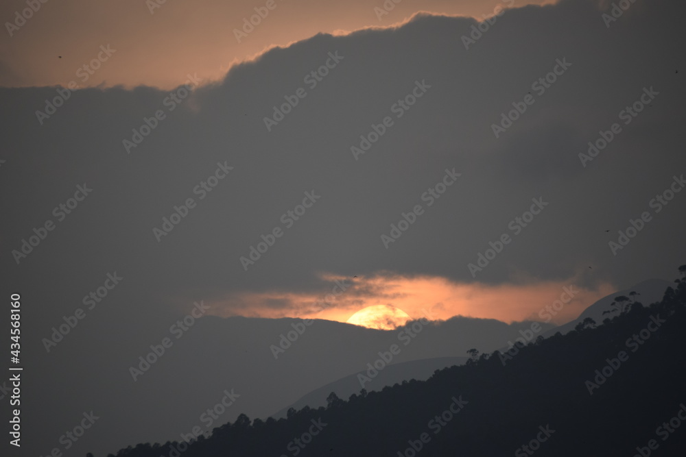A view of sun setting behind the hills of munnar