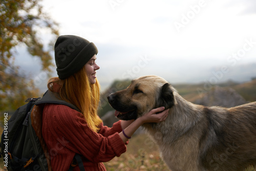 cheerful woman next to a dog outdoors vacation friendship