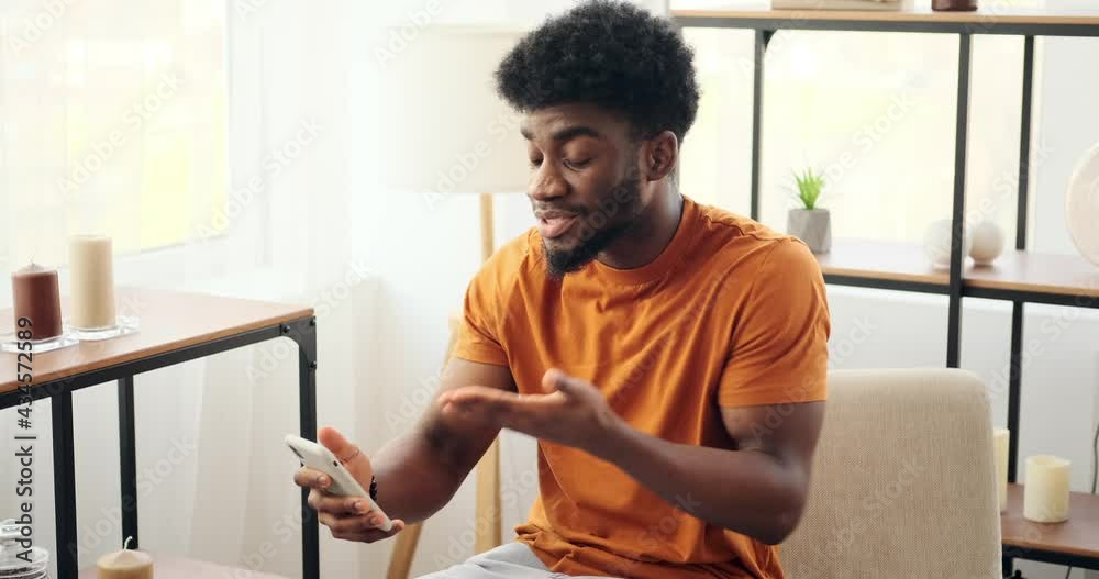 Man video chatting on mobile phone at home Man video chatting on mobile phone at home