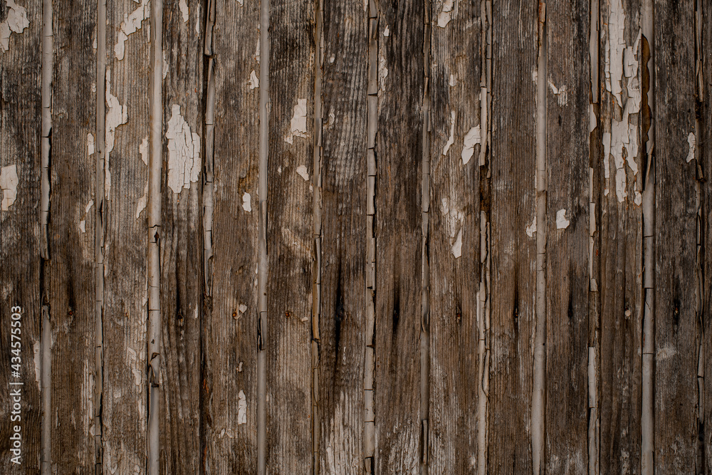 vertical wood planks with chipped and peeling old white paint.