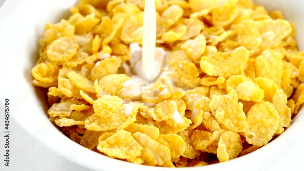 milk pouring in bowl with cornflakes milk pouring in bowl with cornflakes
